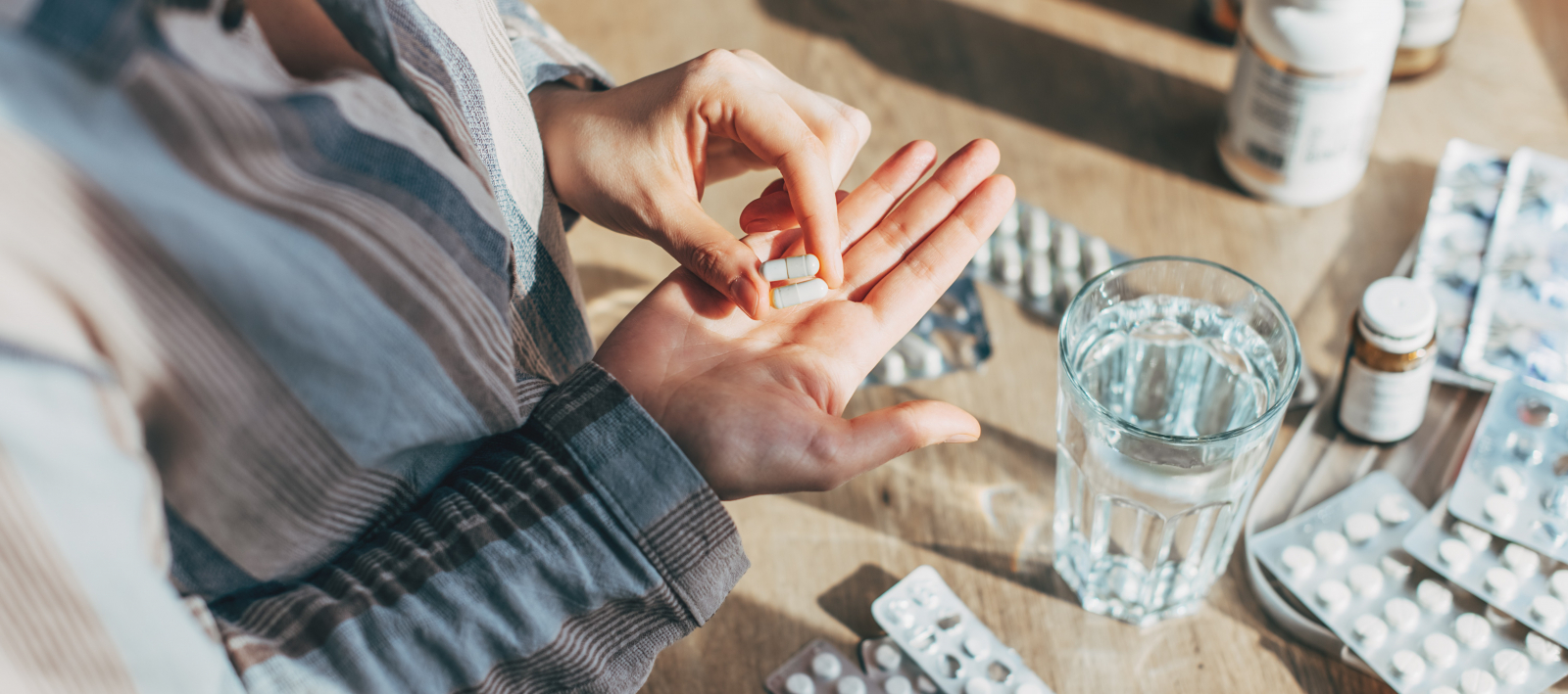 Personne prenant des médicaments sous forme de gélules.